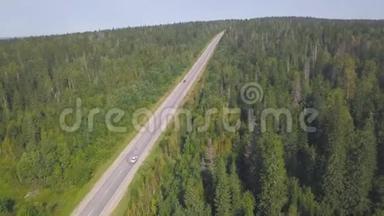 林中乡村公路上白色汽车行驶的鸟瞰图.. 剪辑。 在森林道路上驾驶汽车的美丽俯视图